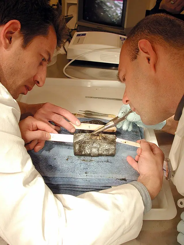 Scientists examine a Civil War-era wallet found during excavation of the Hunley